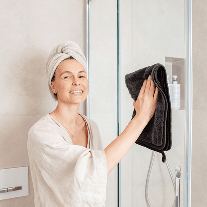 Wiping a shower screen dry with the Domaya drying cloth